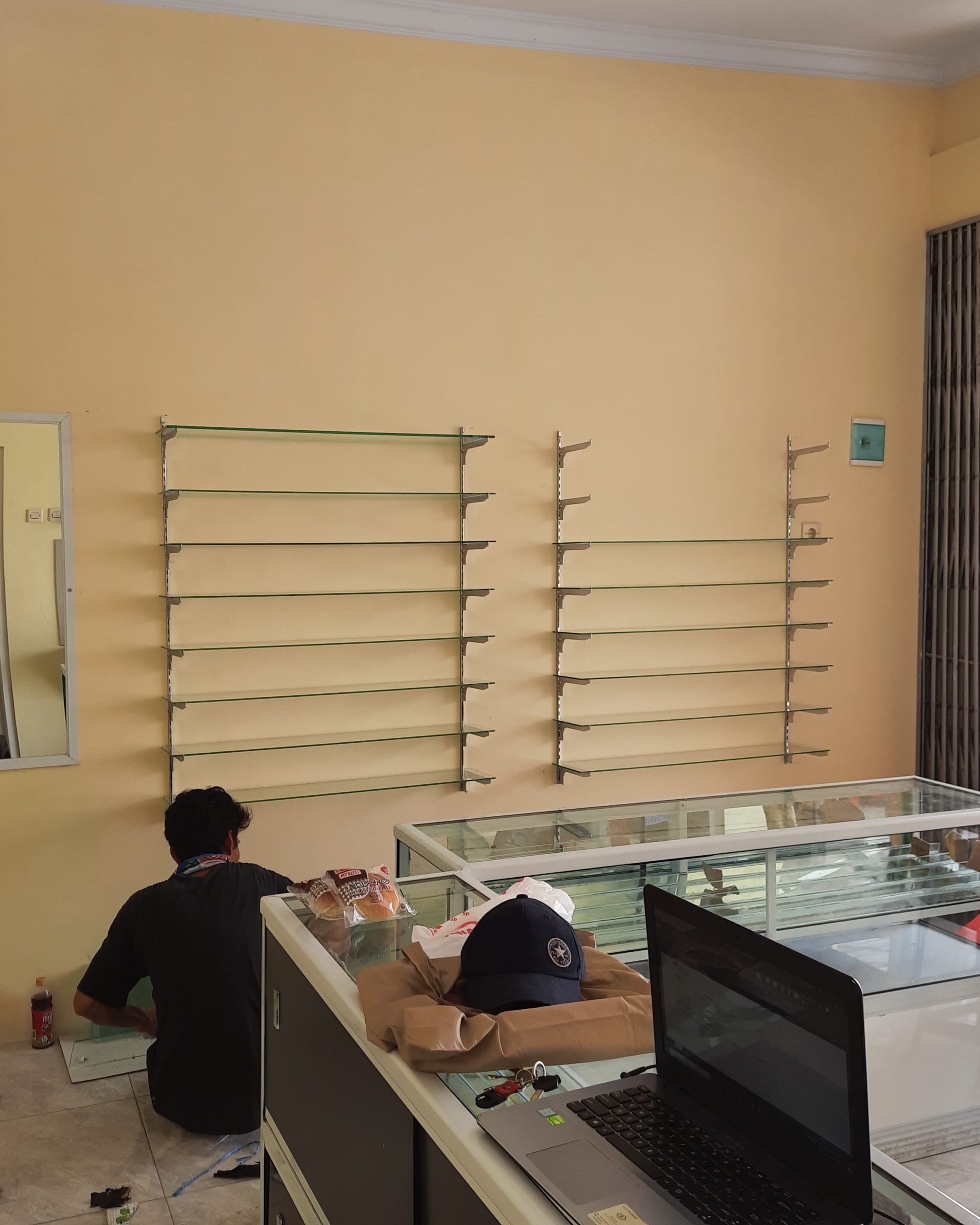 Proses pemasangan etalase, cermin, dan ambalan di GibuKu Kacamata