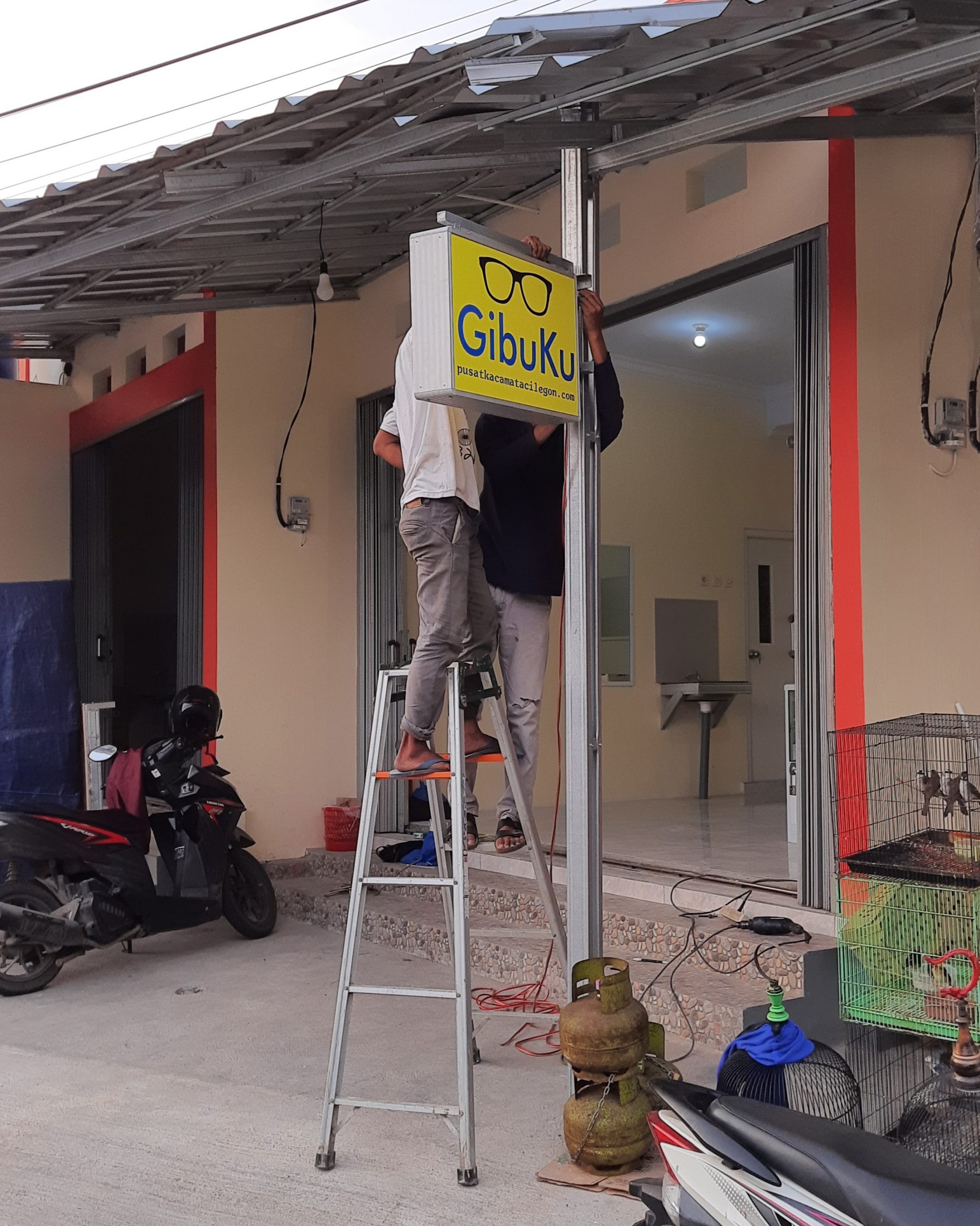 Proses pemasangan neon box di GibuKu Kacamata